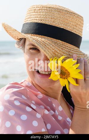 A woman in a white dress with polka dots is on a glade with daisies ...