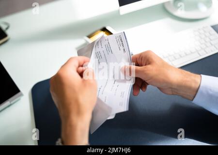 Holding Paycheck Or Payroll Check. Insurance Payment Stock Photo