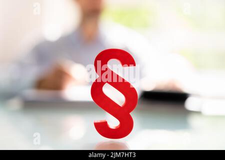 Close-up Of A Red Paragraph Symbol In Front Of Person Working At Workplace Stock Photo