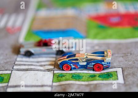 A mix of Hot Wheels toy model cars on a play road Stock Photo