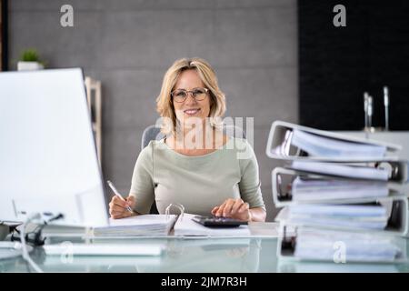 Accountant With Folders Paper Stack Doing Invoice Audit Stock Photo