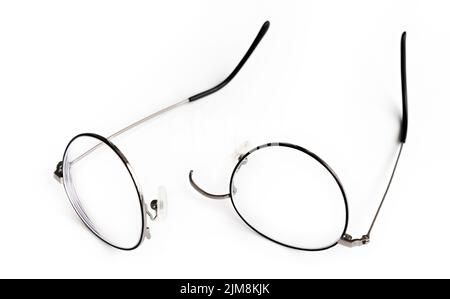 Black round frame eyeglasses have broken. White background. Stock Photo