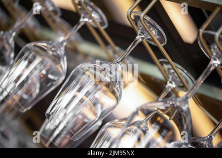 https://l450v.alamy.com/450v/2jm95nx/cocktail-glasses-hanging-above-the-bar-in-the-restaurant-empty-glasses-for-wine-wine-glasses-in-shelf-above-a-bar-rack-in-restaurant-2jm95nx.jpg