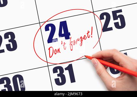 24th day of the month. Hand writing text DO NOT FORGET and circling the calendar date. The text Don't forget reminds of an important meeting. Day of t Stock Photo
