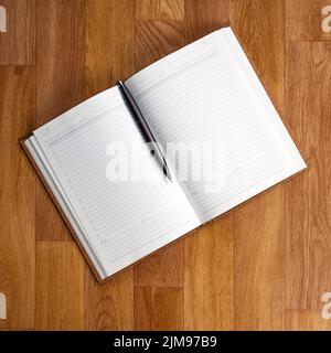 Blank notepad with office supplies on wooden table. Stock Photo