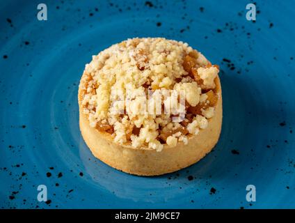 Freshly baked single portion apple pie on a blue porcelain plate Stock Photo