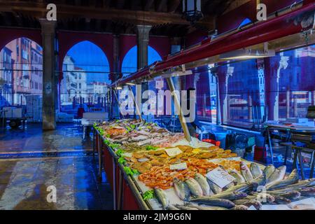 Venice, Italy - March 02, 2022: Scene of the Rialto market, with seafood on sale, sellers, and shoppers, in Venice, Veneto, Northern Italy Stock Photo