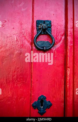 Detail of an red painted door with door knocker Stock Photo