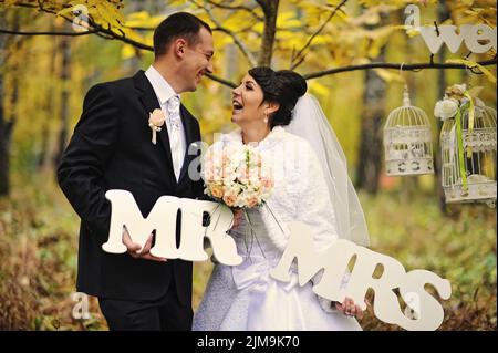 Happy wedding couple in autumn day with sign mrs  mr Stock Photo