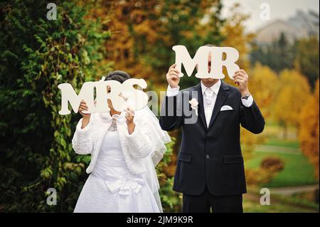 Happy wedding couple in autumn day with sign mrs  mr Stock Photo