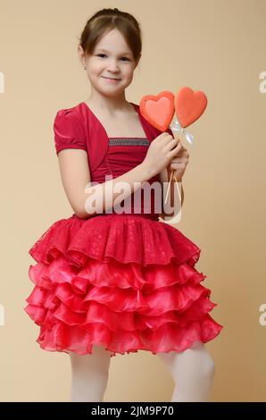 Emotional caucasian little girl holding heart shape biscuits on Valentine Day Stock Photo