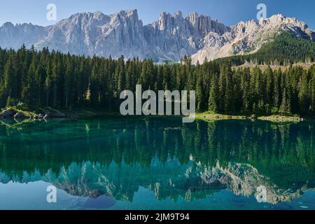 Majestic view of Lake Karersee (Lago di Carezza) ,small emerald green mountain lake in the Dolomites , Italy, in which  Mount Latemar are reflected Stock Photo