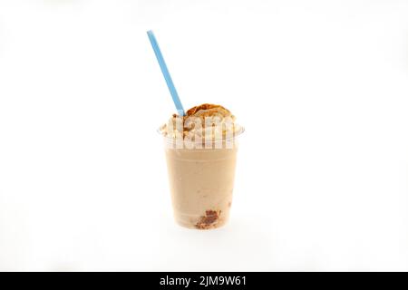 Cookie butter crumbs ice cream gelato shake with whipped cream and blue straw in a plastic cup. Stock Photo