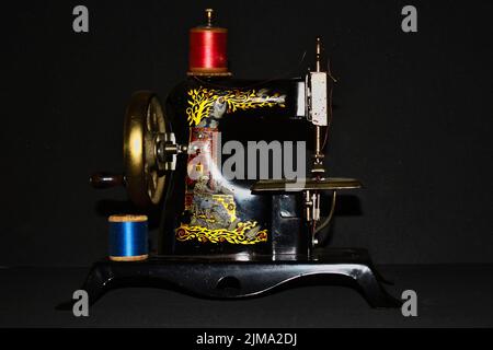A closeup shot of a vintage Sewing Machine isolated with black background Stock Photo