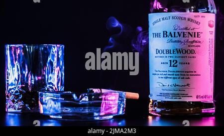 The Balvenie Bottle with a glass and cigarette isolated on a black background Stock Photo