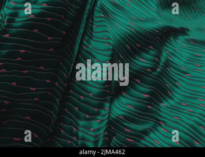 Emerald green satin fabric with red embroidery. Stock Photo