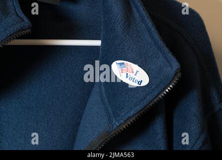 I Voted sticker on blue jacket hung on hanger Stock Photo