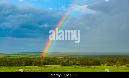 The Rainbow over Rural Landscape after Thunderstorm. Stock Photo