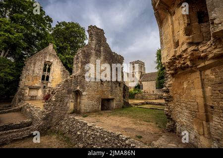 The atmospheric ruins of Minster Lovell Hall with St Kenelm’s Church in the background, Cotswolds, Oxfordshire, England