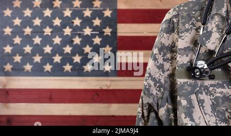 Close up of military uniform jacket and stethoscope with rustic USA flag in background Stock Photo