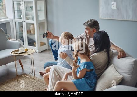 happy man and his family taking a selfie in their apartment. Stock Photo