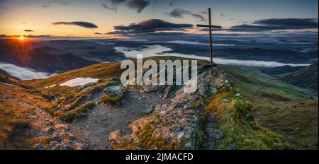 Sunrise on the summit of Ben Ledi in the Loch Lomond and the Trossachs National Park in Scotland. Stock Photo