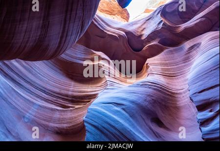 Wavy structures and walls in Antelope Canyon glow yellow, red and blue. Stock Photo