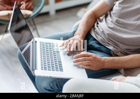 image of a man using a laptop in his apartment. Stock Photo