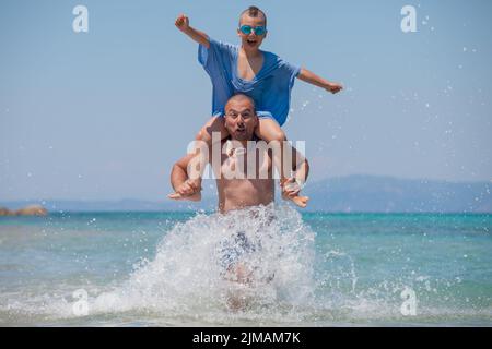Son Splashes Father Shoulders Fun Sea Stock Photo