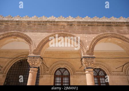 Low angle arch, picturesque ornament carved limestones on architectural arch in Mardin Mesopotamia museum gate. Stock Photo