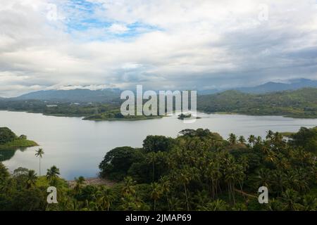 Lake among green hills and mountains early in the morning. Tropical landscape. Victoria Reservoir, Sri Lanka. Stock Photo