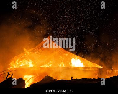 Burning fire flame on wooden house roof Stock Photo