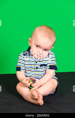 Sad 10 Month old Baby Boy on Green Screen Stock Photo