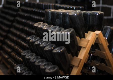 Traditional Champagne bottles being kept for secondary fermentation in the bottle in underground cellar. MÃ©thode champenoise. B Stock Photo