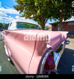 Wide angle view of the tail fin of a classic American road cruiser with light pink paint scheme Stock Photo