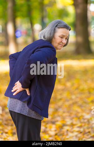 Senior woman suffering from backache outdoors Stock Photo