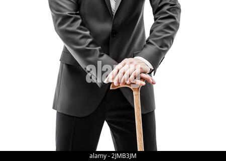 Businessman in black suit holding walking cane stick Stock Photo