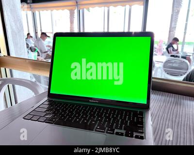 A Mockup image of laptop with blank green screen on on the table Stock Photo