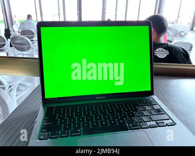 A Mockup image of laptop with blank green screen on on the table Stock Photo