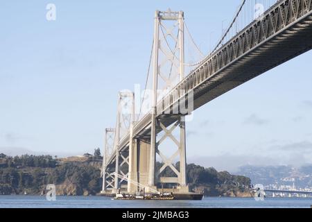 A view of a steel bridge over the river on a sunny day Stock Photo