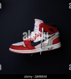 A closeup shot of a worn-out Air Jordan 1 beaten-up sneaker in a dark background Stock Photo