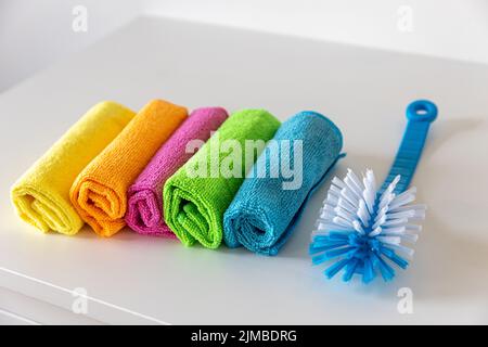 Multi-colored fiber cloths for dusting and a plastic brush Stock Photo