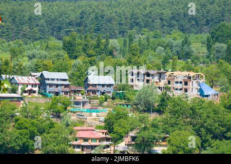 Beautiful view of Pahalgam during summer season surrounded by mountains and green fir and pine tree line forest landscape. Stock Photo