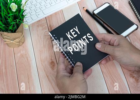 Businessman holding a notepad with key points text. Business concept. Stock Photo