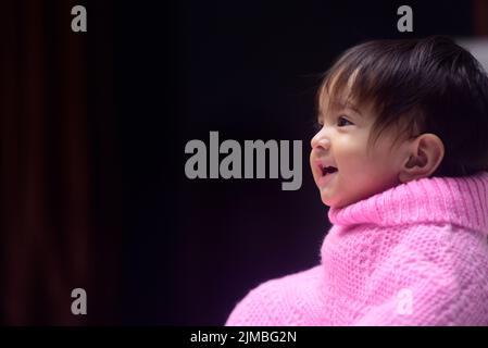 A cute 13 months old Indian baby girl wearing a poncho Stock Photo