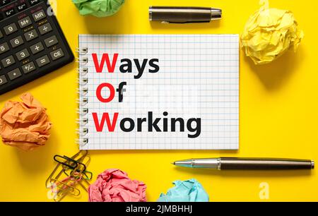 WOW ways of working symbol. Concept words WOW ways of working on white note on a beautiful yellow background. Black calculator and pen. Business and W Stock Photo