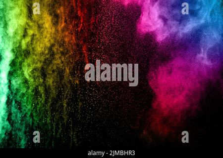 Abstract multicolored powder explosion on black background. Color dust particle splattered . Stock Photo