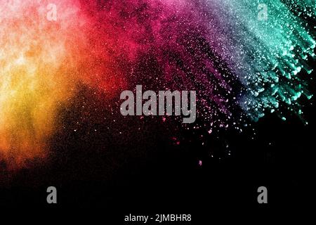 Abstract multicolored powder explosion on black background.Freeze motion of color dust  particles. Stock Photo