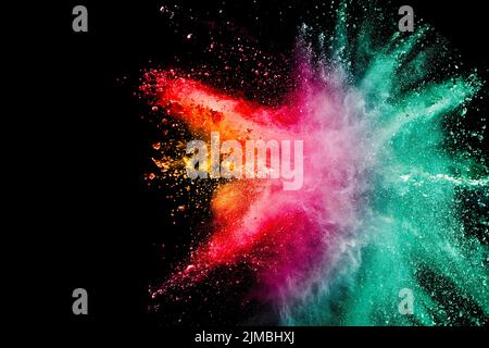 Abstract multicolored powder explosion on black background. Color dust particle splattered. Stock Photo