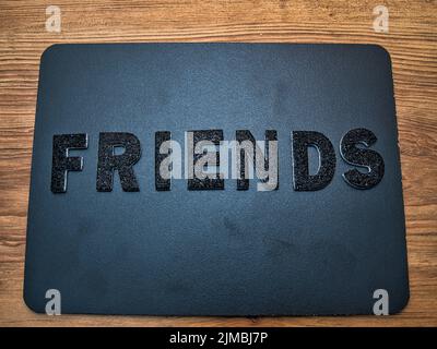 The word Friends in black letters on a black chalkboard background. Perfect for showing you care on a social media post. Stock Photo